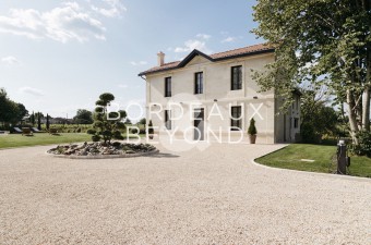 Situated in the Fronsadais, close to the small shops of a pretty, dynamic village, less than 15 minutes from Libourne with its TGV train station and 35 minutes from Bordeaux, this traditional residence with its white Brétignac stone facade boasts unexpect